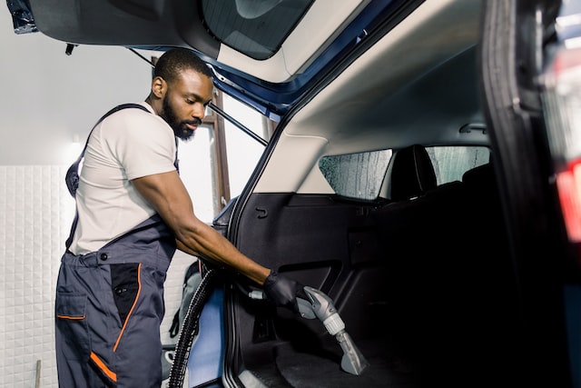 african male worker vacuum cleaning